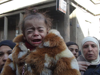 A malnourished child weeps on Yarmouk's main street in February 2014. © UNRWA Photo by Rami Al Sayed