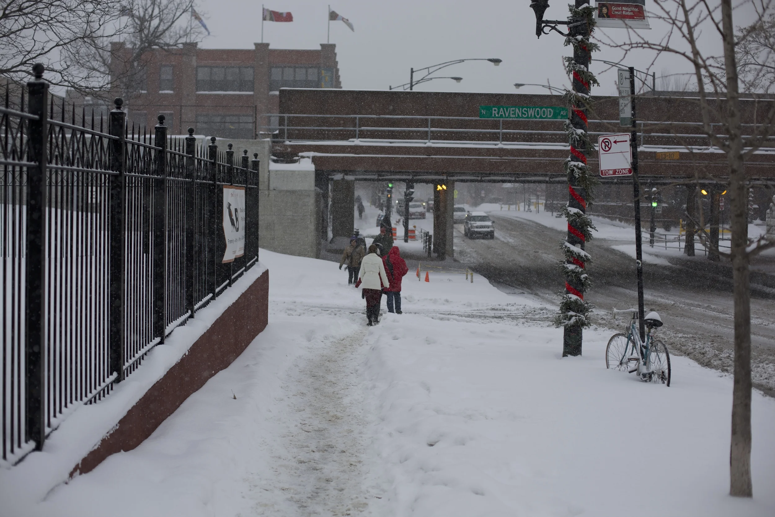 Commuters trudge through the snow near ravenswood, forging their own path when shoveling is neglected.