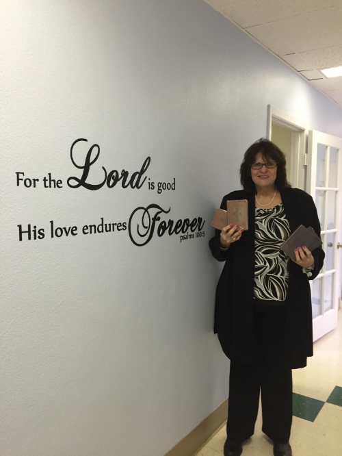 Vanessa Lynch, First Refuge Ministries Executive Director, holds up some of the donated Bibles.