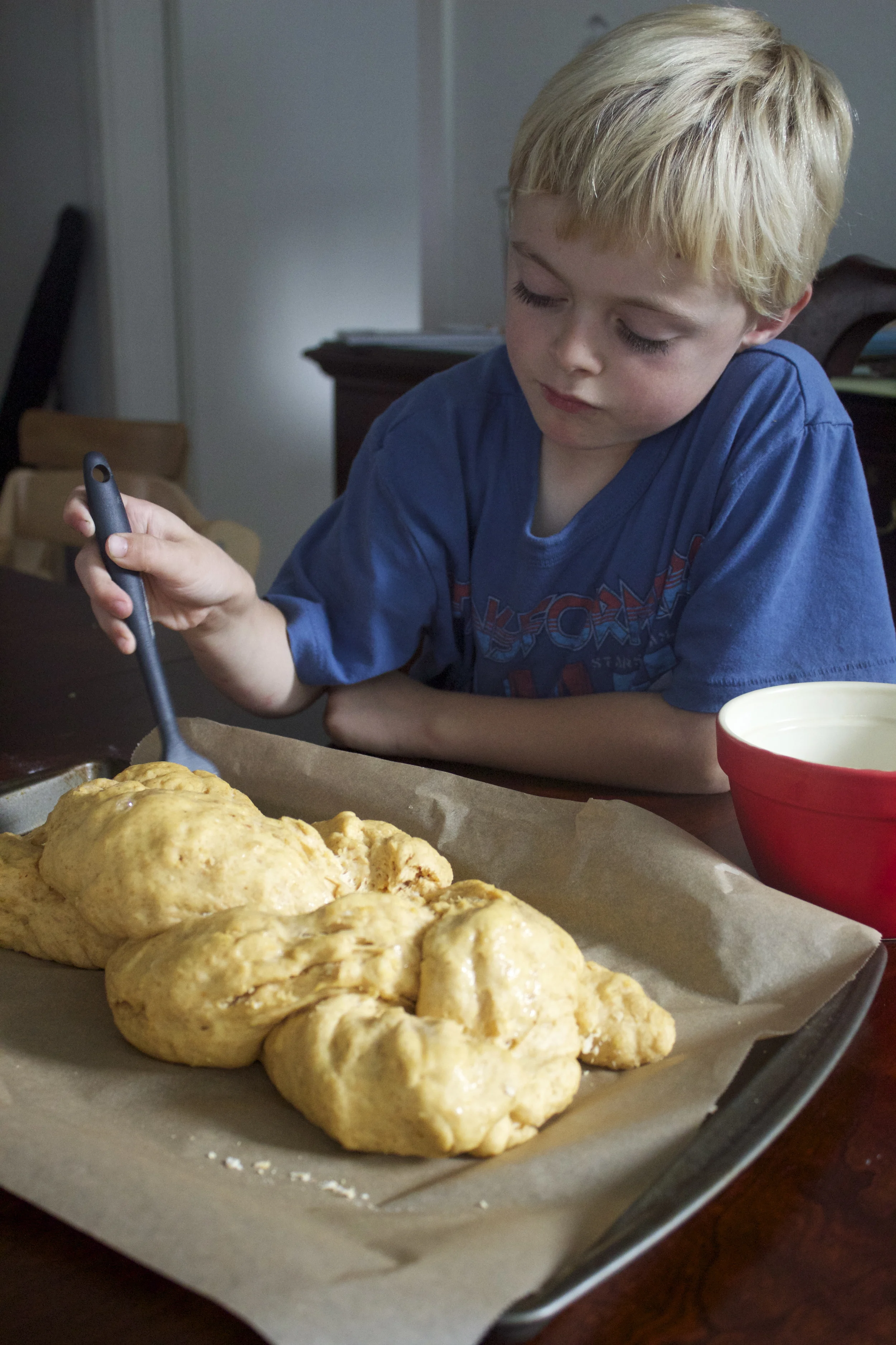 Painting on the egg wash so our lumpy challah could be shiny.