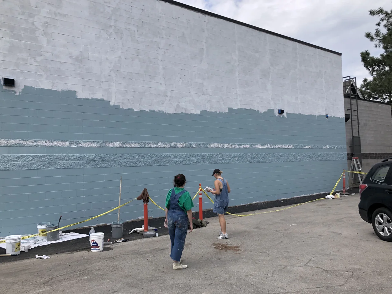 Provo City has a mural program that helps pay for outdoor murals. Most tend to be fairly small but they really wanted to make something large on our building. The artists are pictured here working on the background.