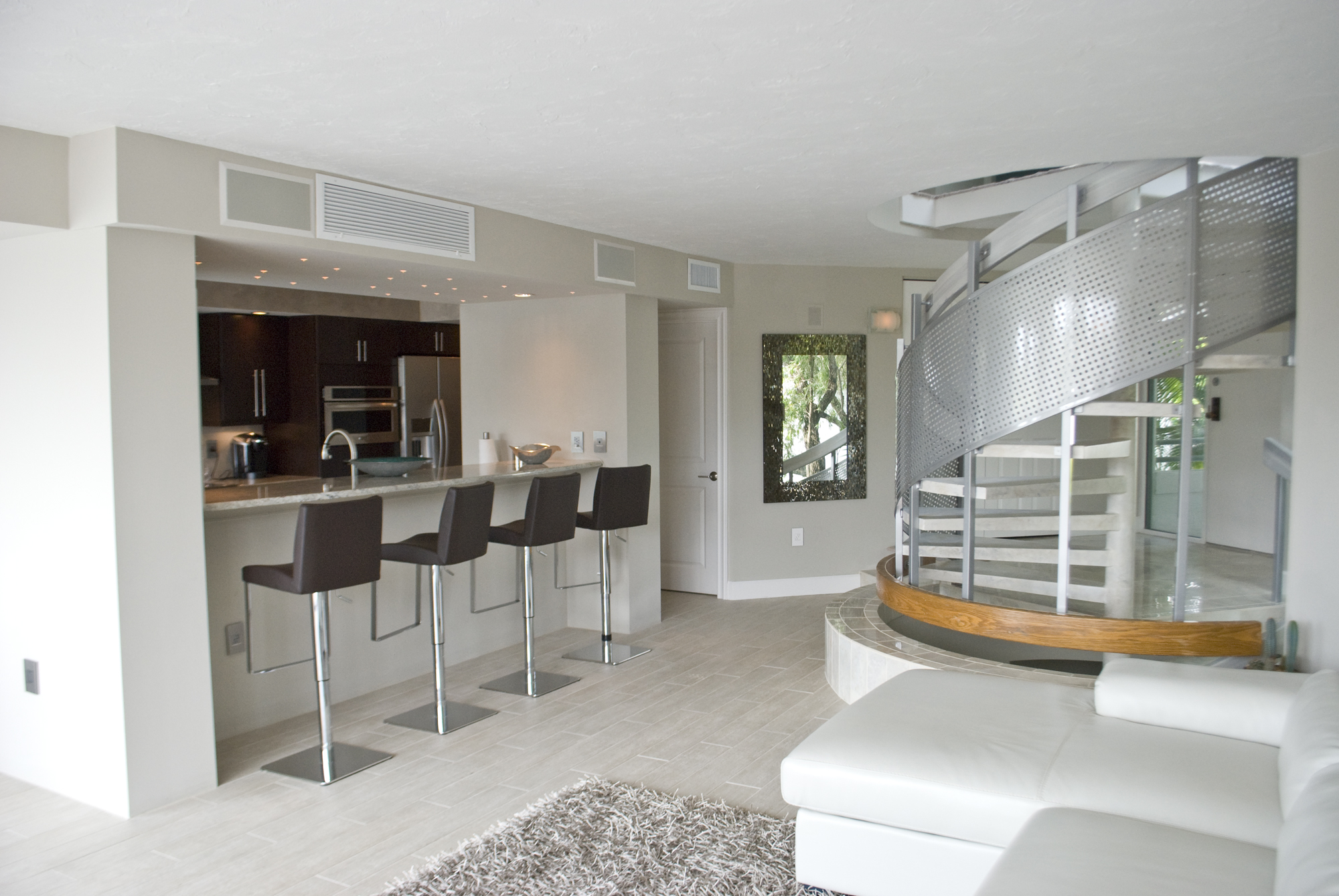 A view of a completely renovated condominium with Venetian Plaster, modern cabinets and faux marble finish on the stairs.
