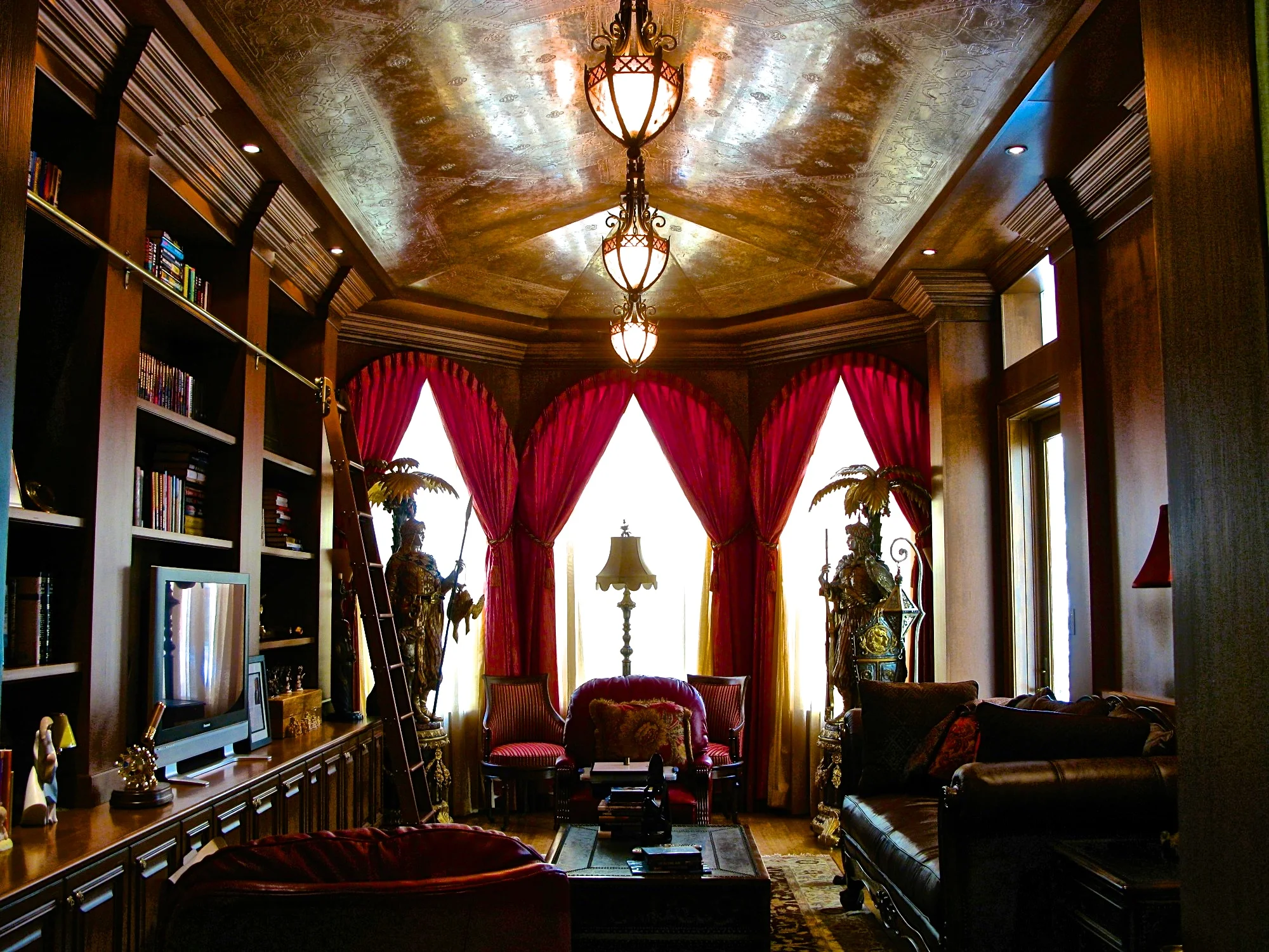 A Celtic border and Moorish bas relief stencils on a Venetian Plaster ceiling mimics tooled leather in this stunning library, faux bois accents makes the look complete.