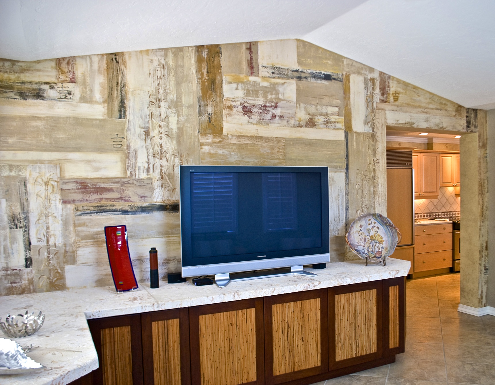 Den walls in a heavily textured Venetian Plaster stenciled with bas-relief oriental characters and bamboo.