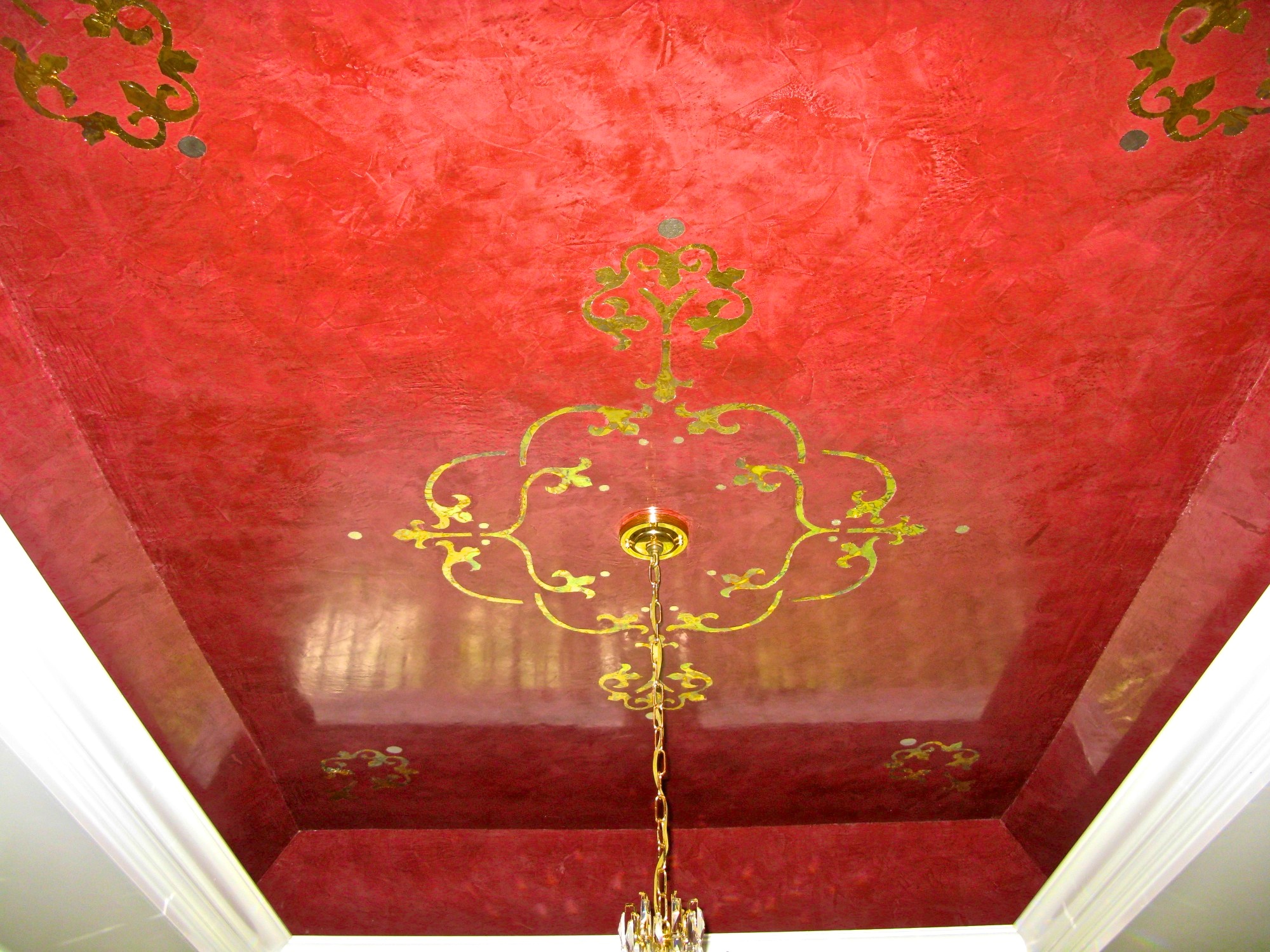 Polished Venetian Plaster with stenciled gold leaf accents creates a mirror reflection on the tray ceiling in this sophisticated private residence.