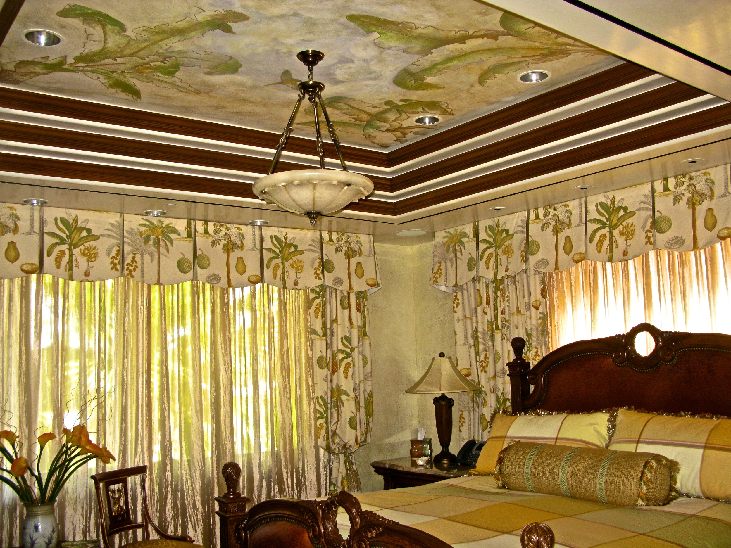 Venetian Plaster tray ceiling handpainted with a tropical scene of birds and bananas. Walls are a textured snakeskin in green Venetian Plaster with cream and gold waxing.