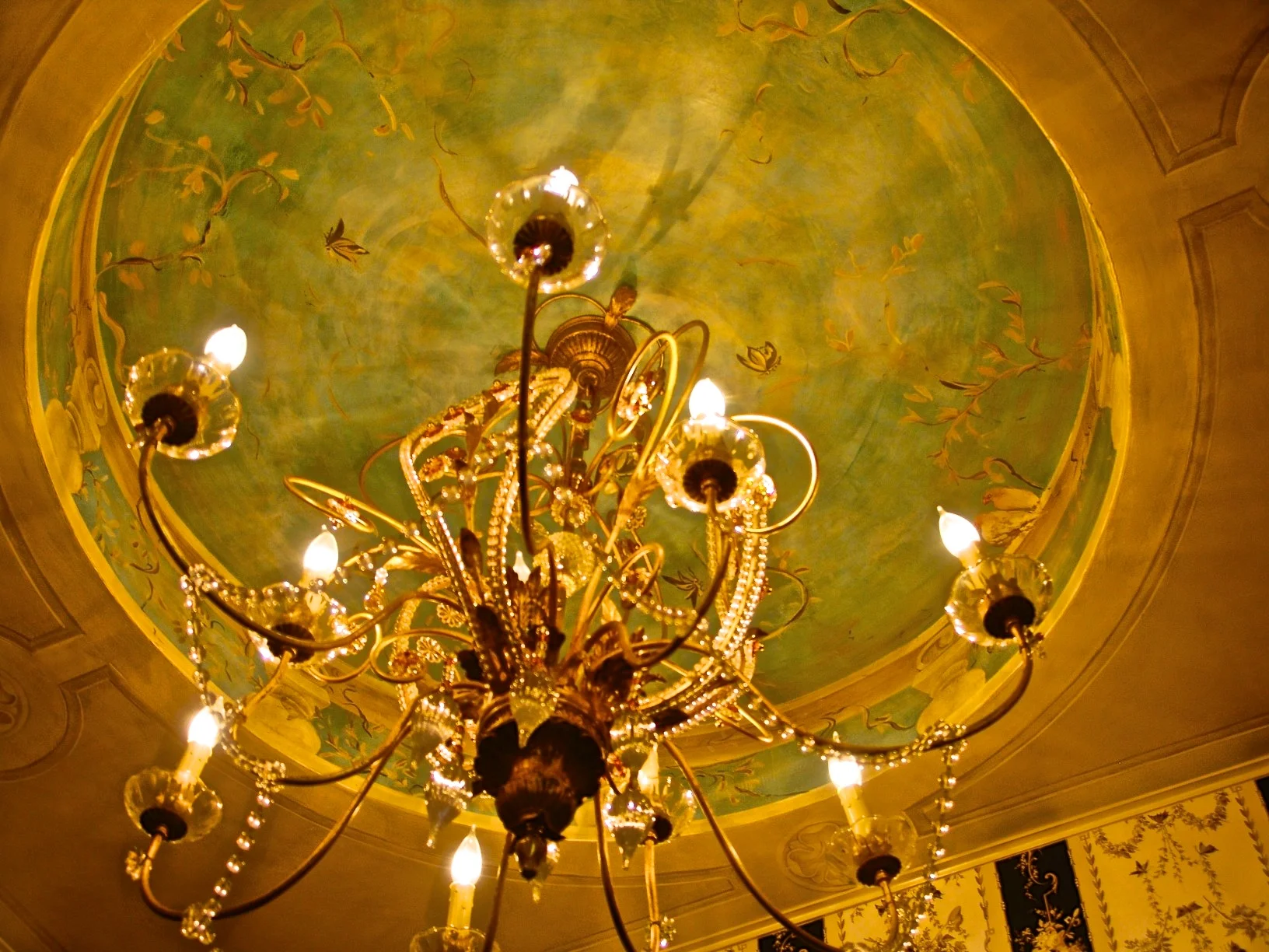 Hand painting of butterflies and vines embellish this sky-toned Venetian Plaster tray ceiling.