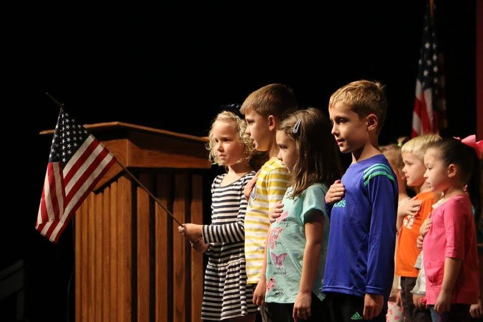 Students recite the pledge of allegiance at daily chapel, held in the auditorium.