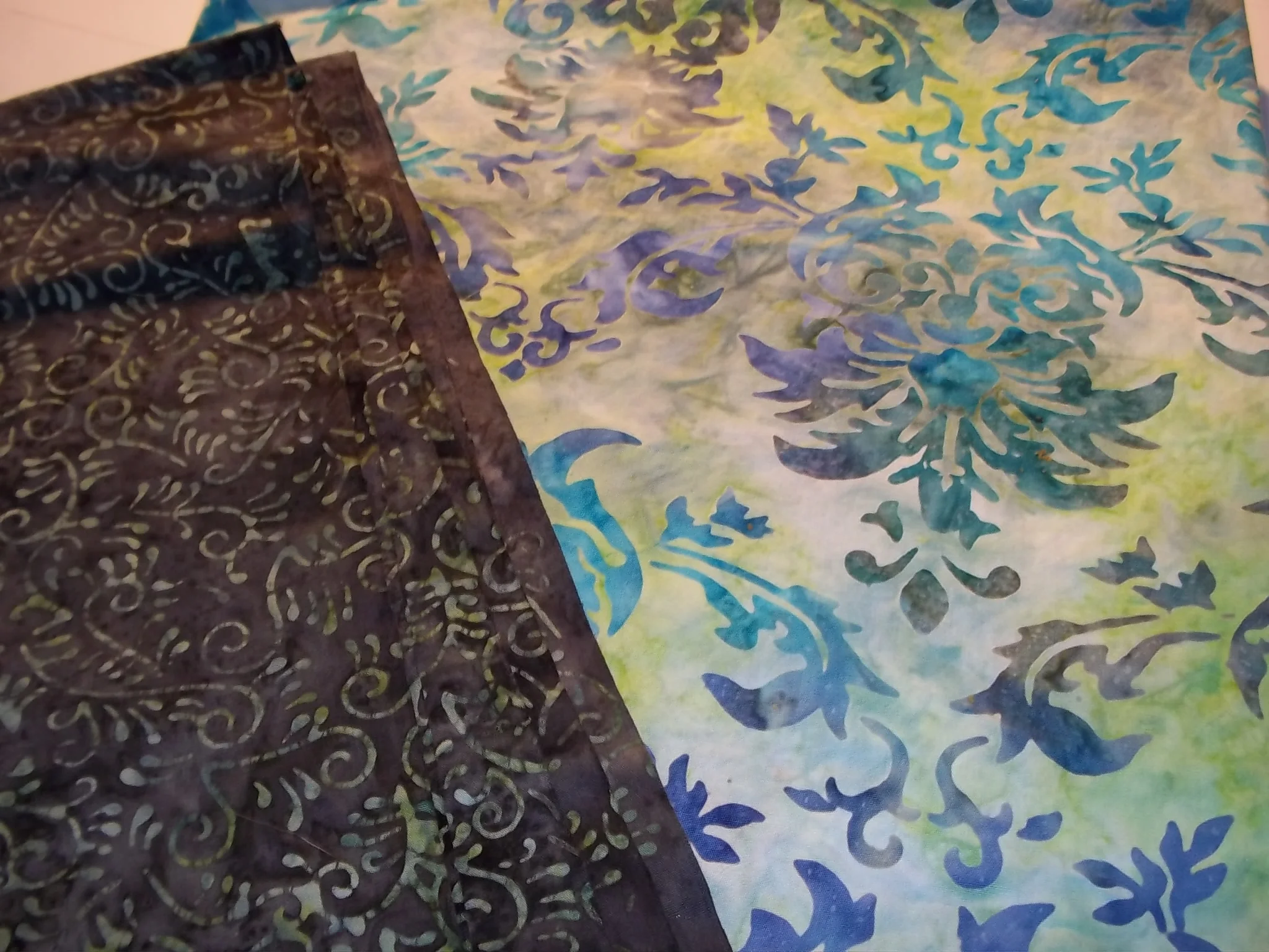 Grey with green swirls for top fabric. Blue and green multi-color patterned background.
