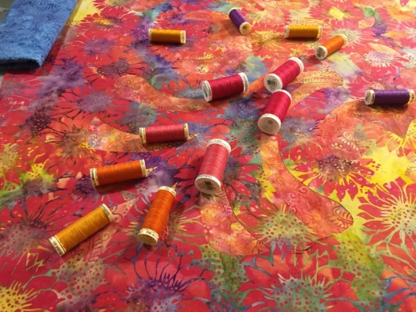 An assortment of thread colors to augment the design and fabrics to create a complete whole.