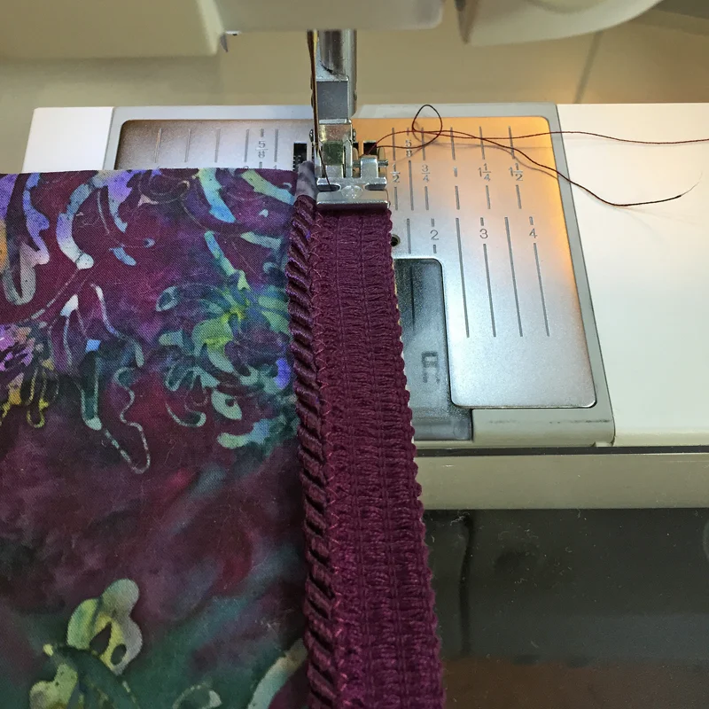 Pic 4.Lay piping on front of pillow, aligning woven edge with raw edge of top. Use your zipper foot and left needle position to sew it down.