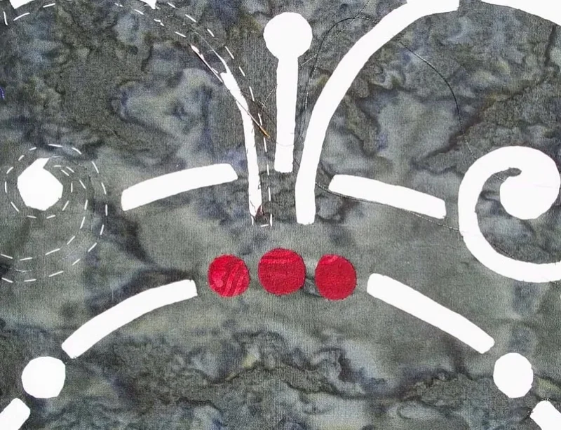 pic. 7. Reverse applique complete on center under-colored circle group. The rest of the shapes are reverse appliquéd to reveal the white background fabric.