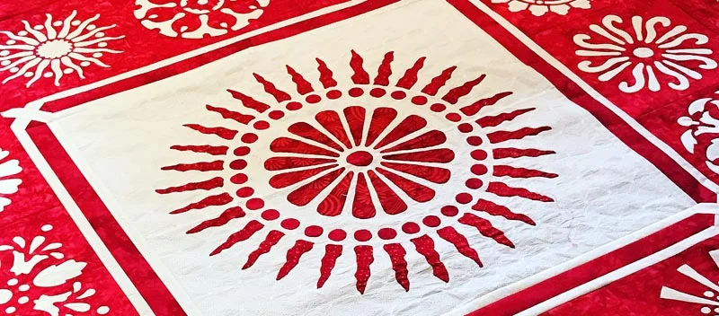 A Red & White quilt with lots of applique and reverse applique circles.