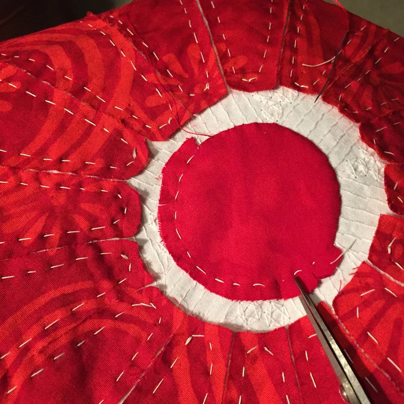 Clipping Up to it, but not through it. Clip perpendicular to basting line and 2-4 threads away from it.