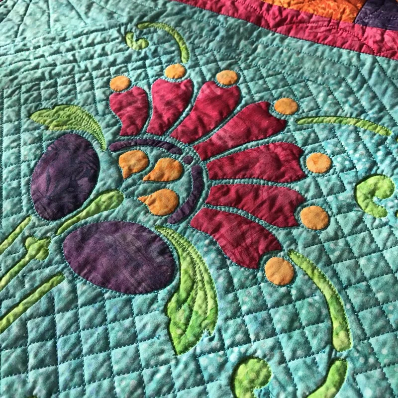 Quilt in the green reverse applique space, in the ditch around the applique petals, and a 1/2" cross-hatch and frame.