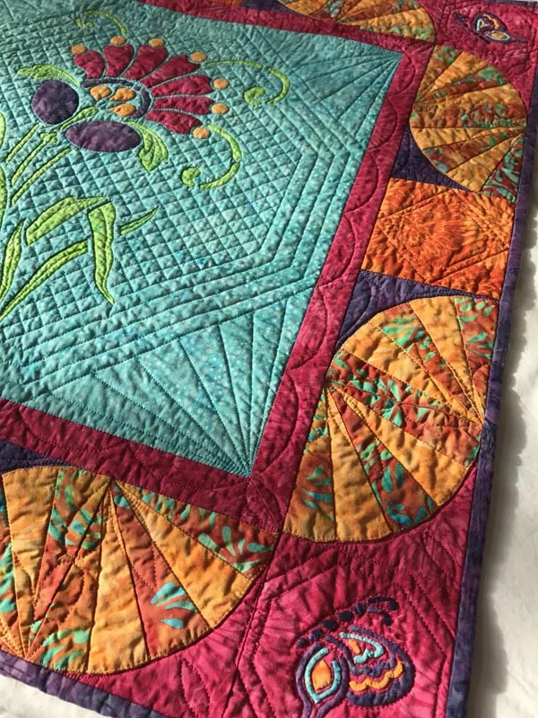 Quilted in the ditch around the butterfly wing bits and an octagon around the butterfly corner blocks, and a diamond in the dark orange squares.