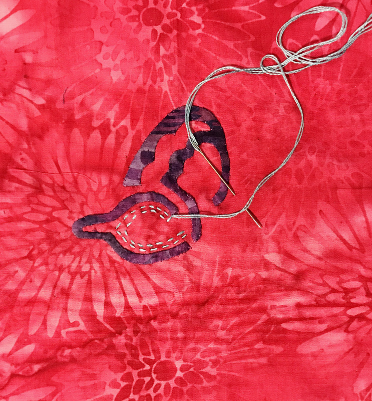 Basting outline of turquoise wing bit.