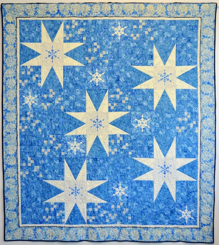 Twinkling Flurries Quilt VI (76" x 84"). hand or machine reverse applique and machine pieced. Designed for Island Batiks Fall 2016. Published in Fons & Porter's Holiday Issue, Oct. 2016.