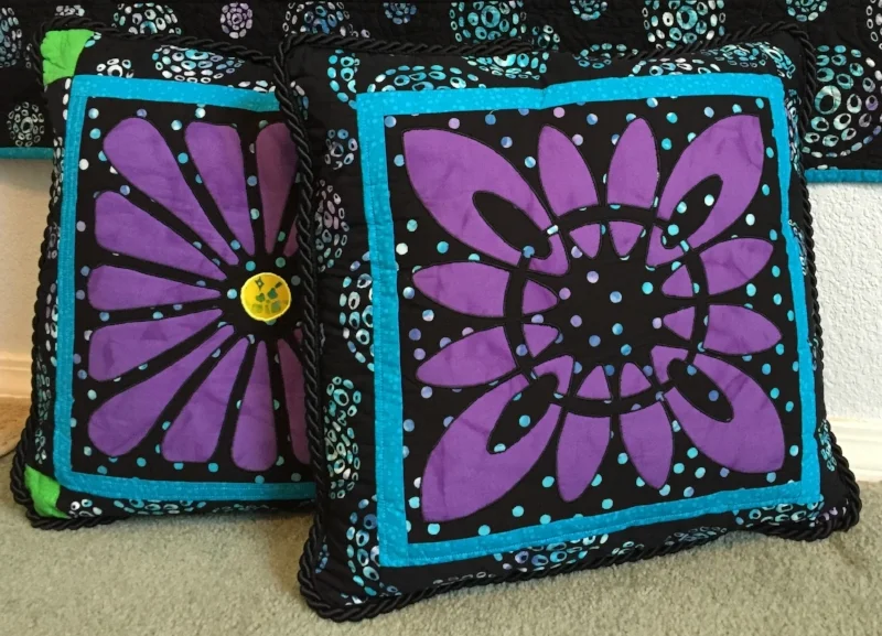 Blocks 13 and 6 from Midnight Explosion Quilt VII created as pillows. Created by machine reverse applique.