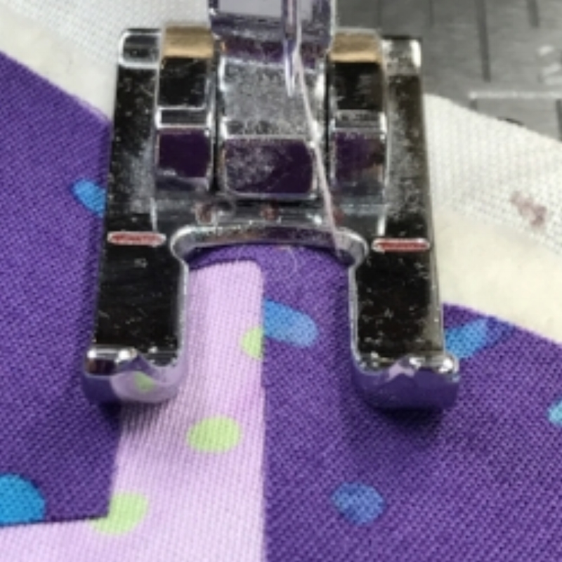 Center notch aligned with raw edge to be stitched. Dark purple is my top fabric and is on my right of where I'm going to stitch. Light purple is my background fabric and is on my left of where I'm going to stitch.
