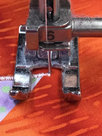 2. Raise the presser foot and pivot piece to the right so that the presser foot is parallel to the stitched leg of the acute inside point. Lower the presser foot.