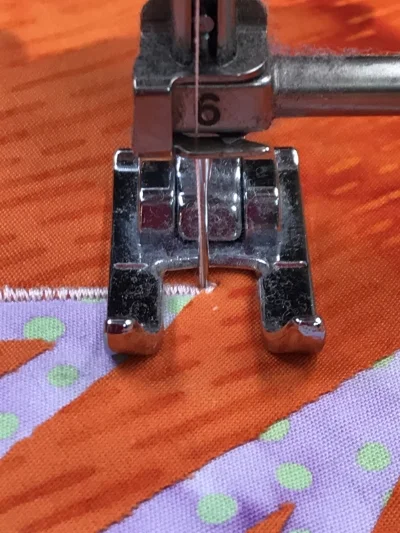 3. Take one stitch so the needle end s in the down position in the left hand side of the satin stitch. Raise presser foot.
