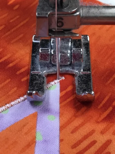 4. Pivot piece a bit more to the right so the presser foot is perpendicular to the un-stitched leg of the acute inside point. Lower the presser foot and sew.