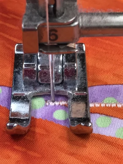 3. Lower the presser foot and take one stitch so the needle is down in the right hand position of the satin stitch. Raise the presser foot.