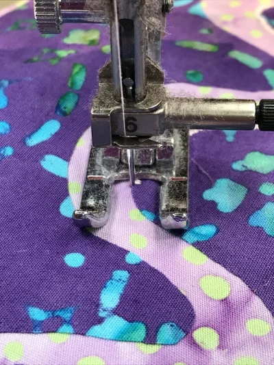 4. After pivoting my piece, ever so slightly, to the left, so my presser foot is perpendicular to the raw edge, I'm ready to lower the presser foot and stitch another 3 +/- stitches.