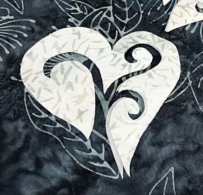 Peel fusible paper off of white heart and position 1/2" from napkin edge.