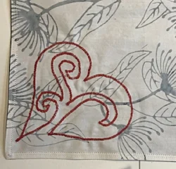 White side of napkins. Red reverse applique heart outline shows through to back of napkins.