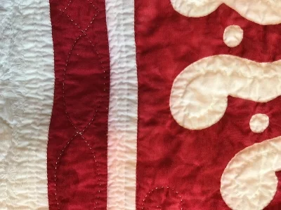 Sashing and block 11 tinged pink from bleeding red dye.