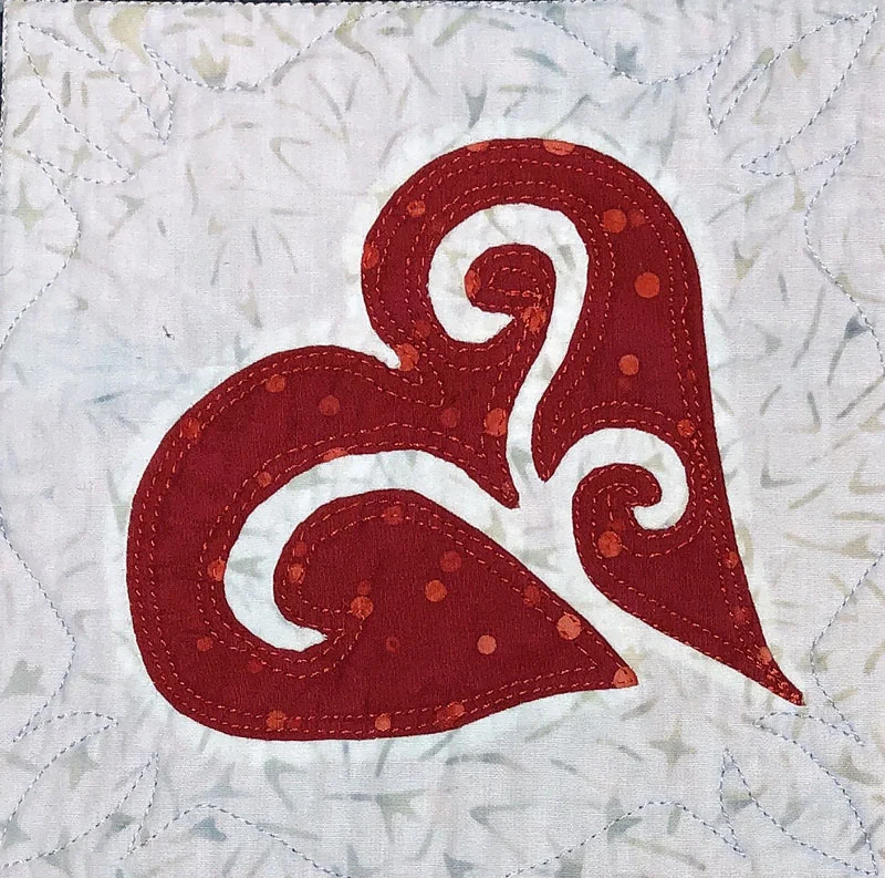 6” Heart block from Snowy Hearts table runner IX stitched by hand reverse applique.