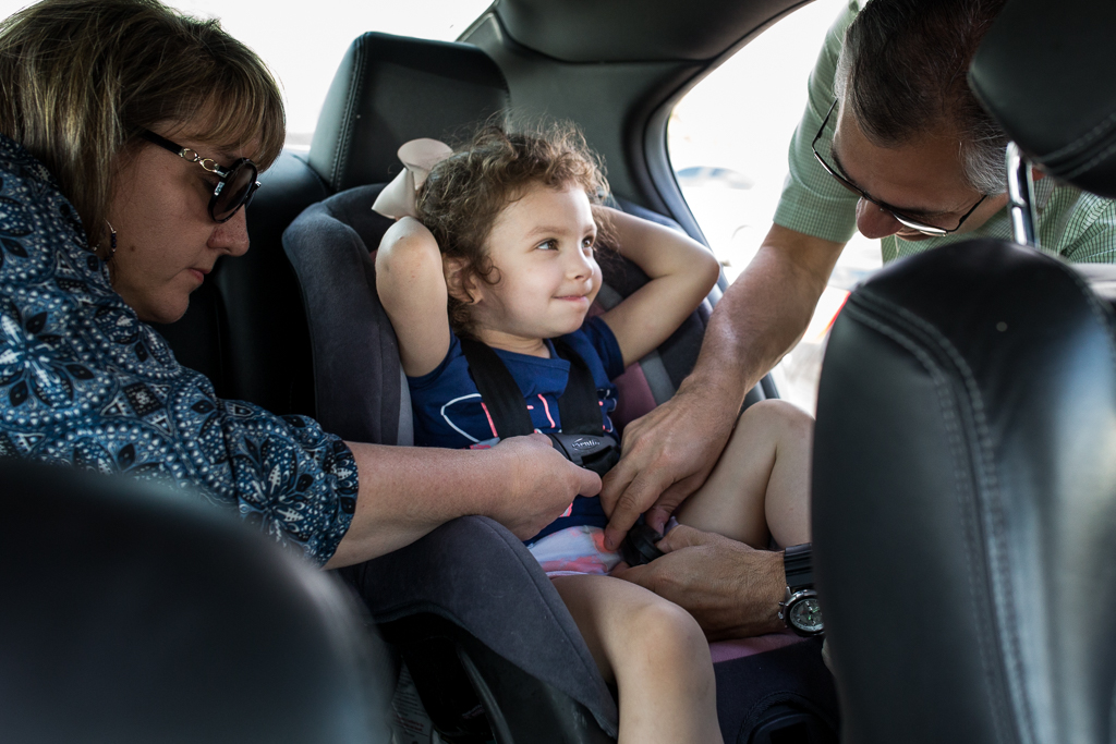 girl with grandparents in car