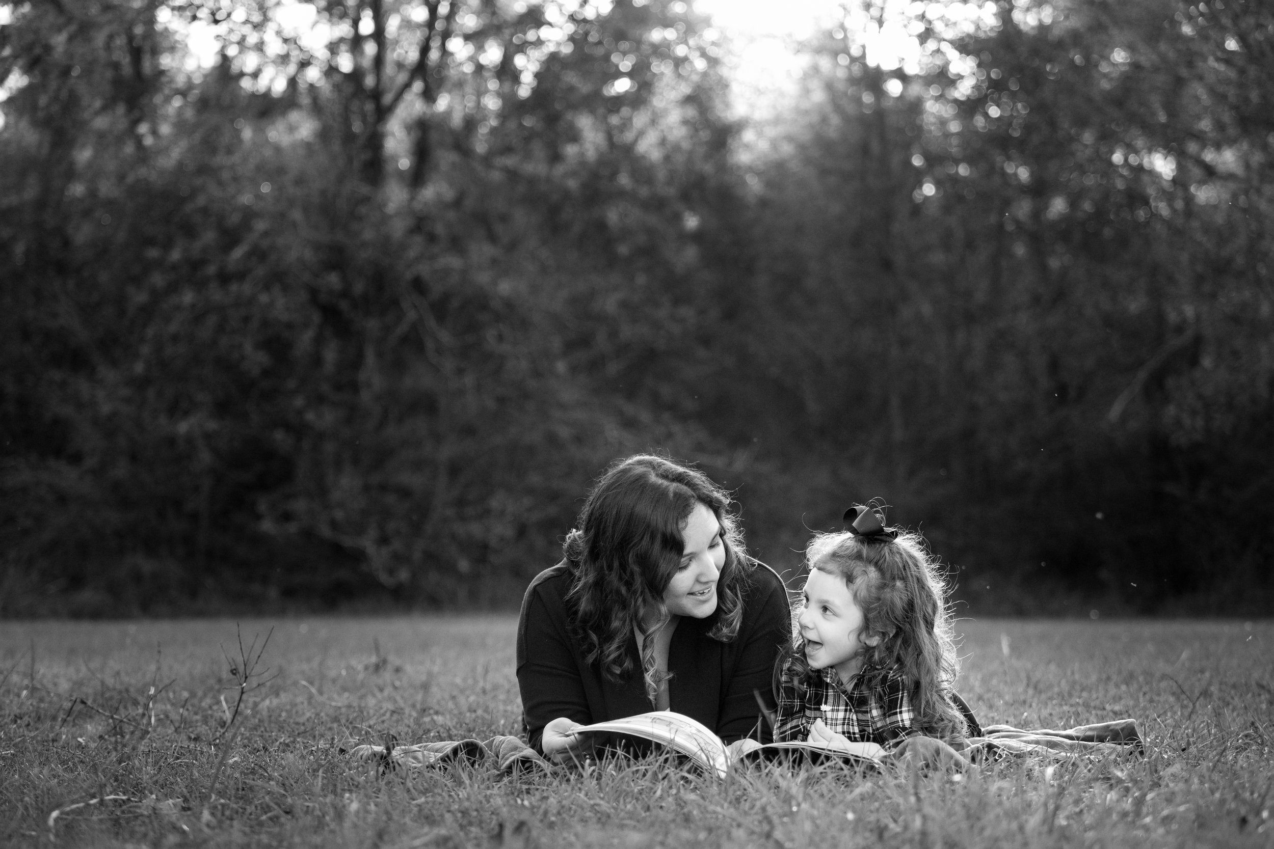 mom and daughter reading outside in family photography session