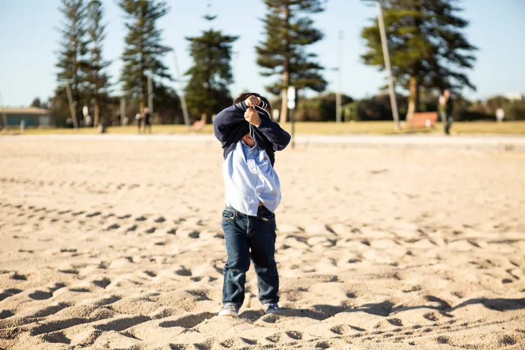 little boy being cheeky on beach
