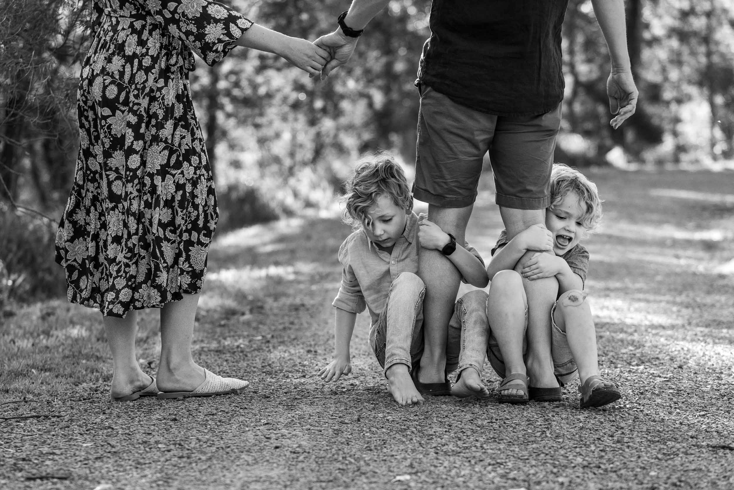  family photography melbourne with two boys sitting on dad’s feet 