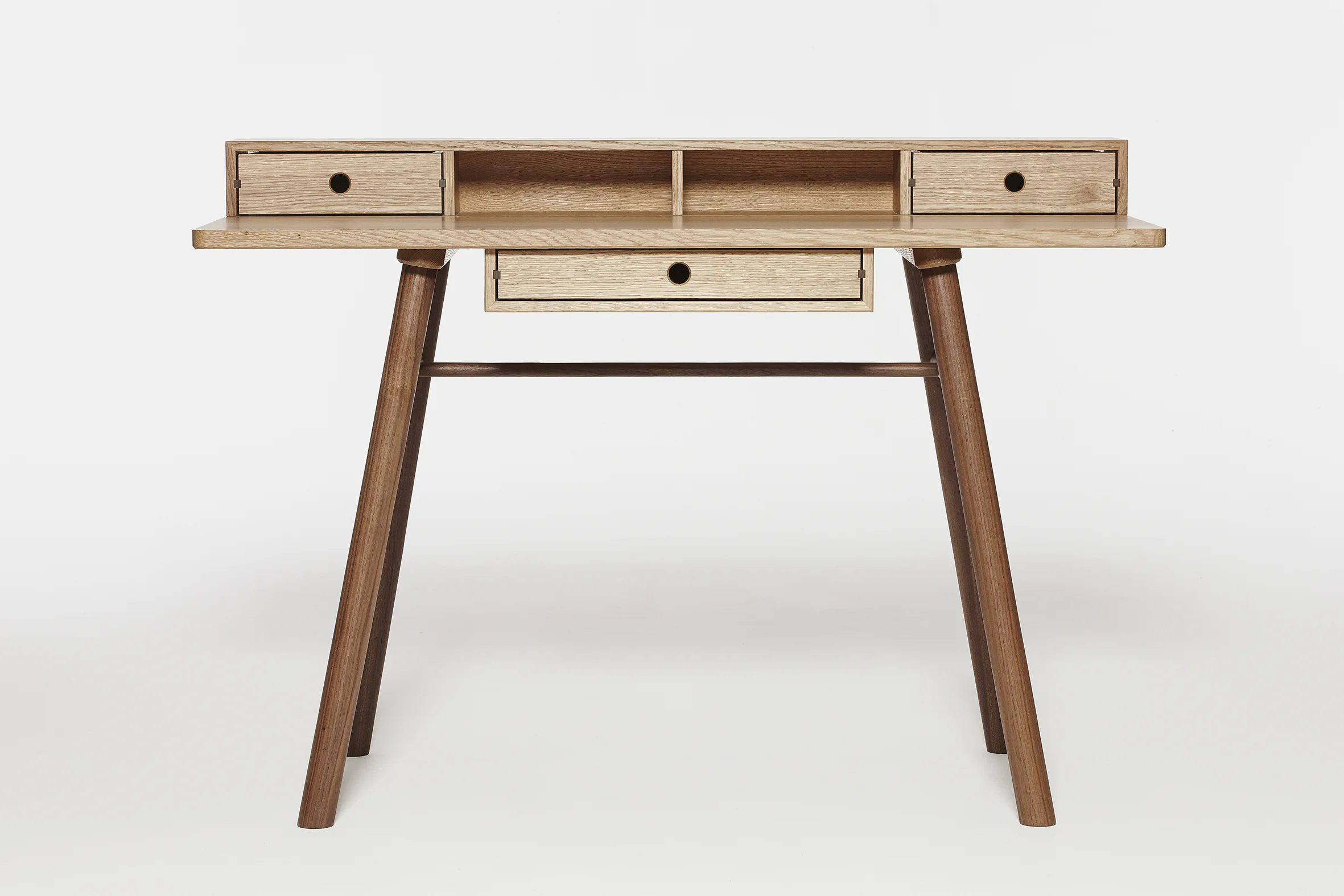 a studio image of a wooden desk with three drawers, front view