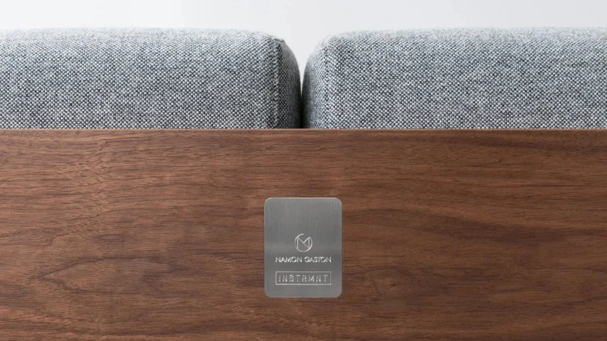 close up back of walnut sofa bed frame with makes badge in silver