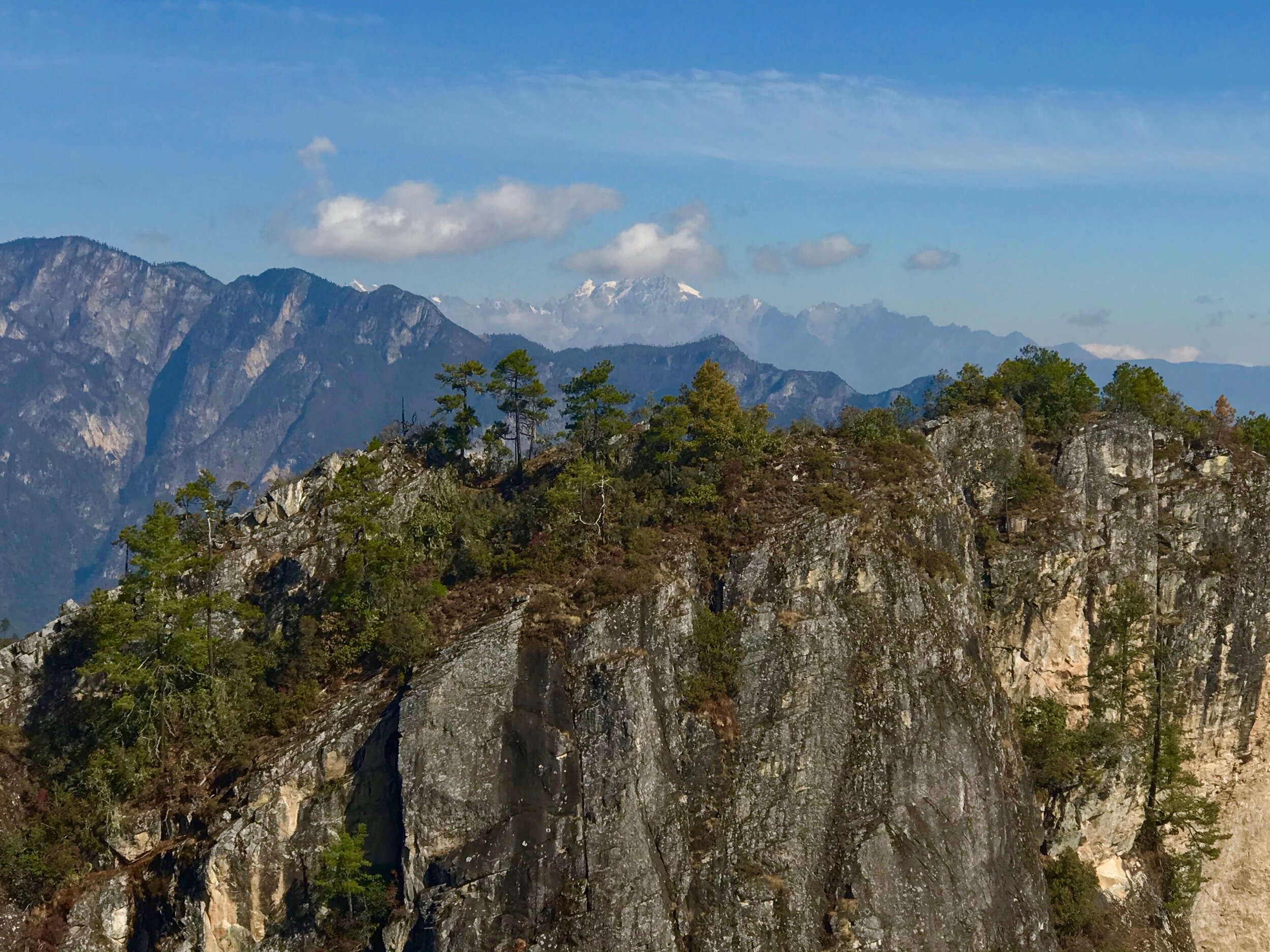 Incredible views from the top. The twin summit of Baiyansi rises across the gap. The huge limestone mountains of Shigu rise on the left. Jade Dragon Mountain (5597m/18470 ft.) rises in the distance.