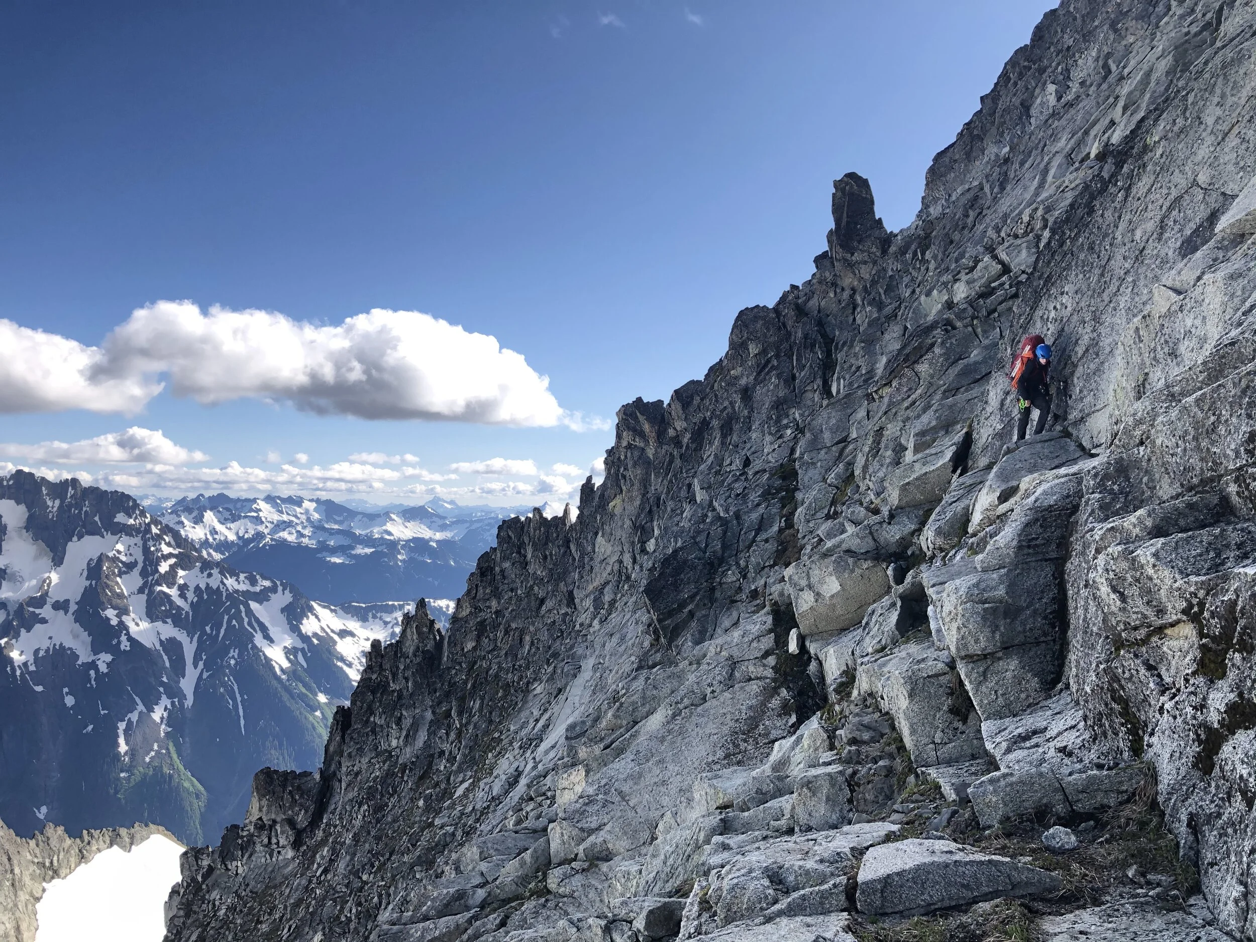 Woody reaches the bottom of the more exposed climbing on the Southeast Face to gain the grassy ledge system leading to the rappel station onto the glacier.