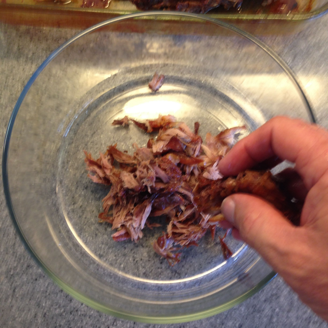 I use my fingers to shred the tender pork, but I suppose you could use a fork.