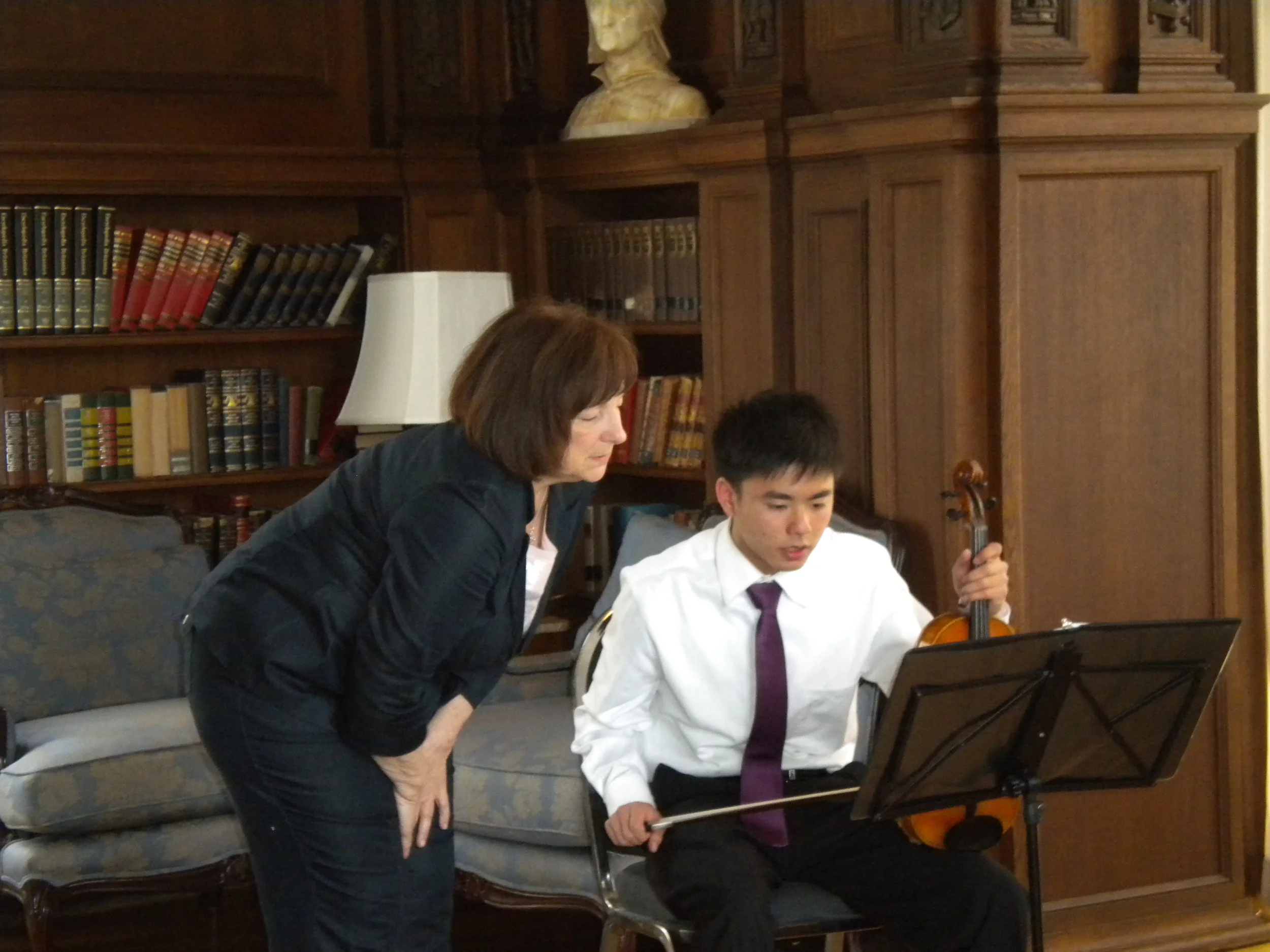 Director Susan Bates with violinist Tim Yu in the Kohl Mansion Library