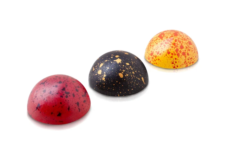 Three speckled chocolate bonbons on white - white background food photography