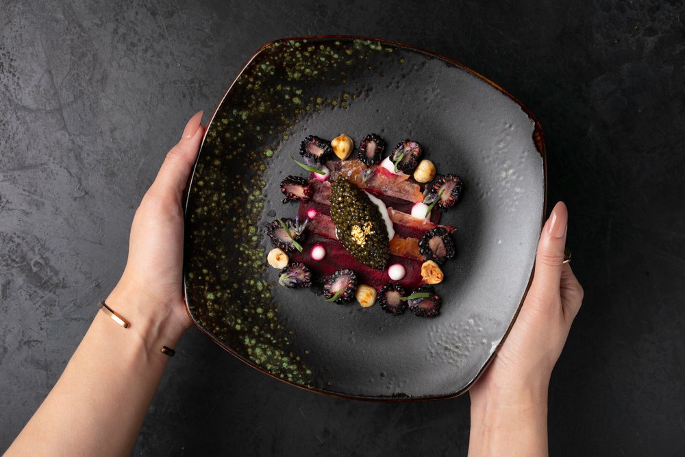 Hands holding a plated dish, food lifestyle photography