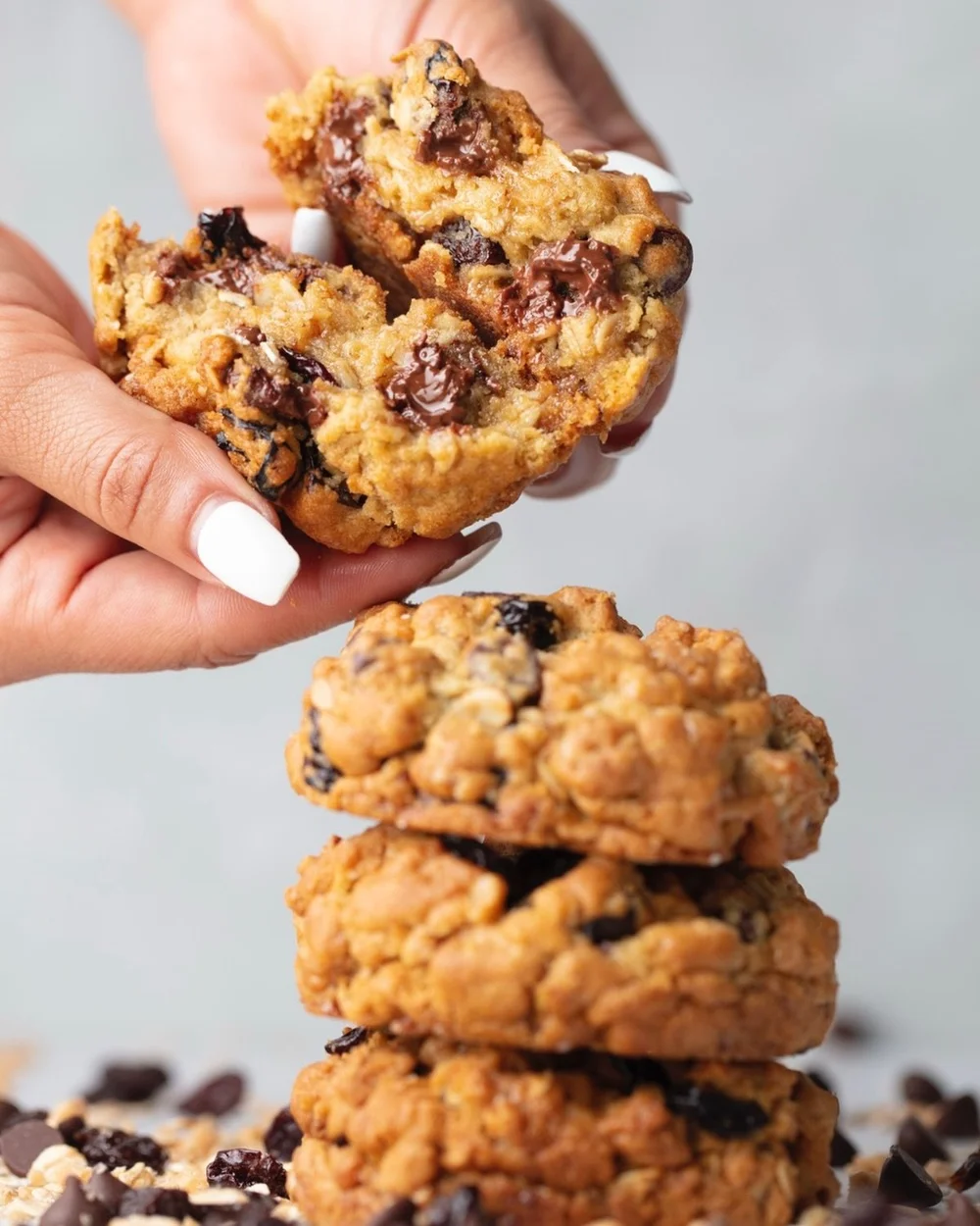 Hand breaking an oatmeal chocolate chip cookie, bakery lifestyle photography