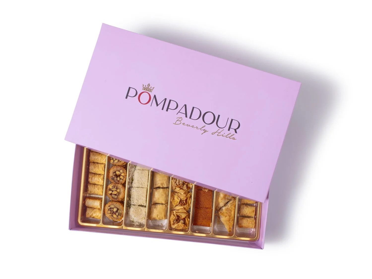 A pink box of assorted petit fours and cake bites from POMPADOUR Beverly Hills, with the box lid partially open to show the treats inside. Beverly HIlls food photographer and stylist 