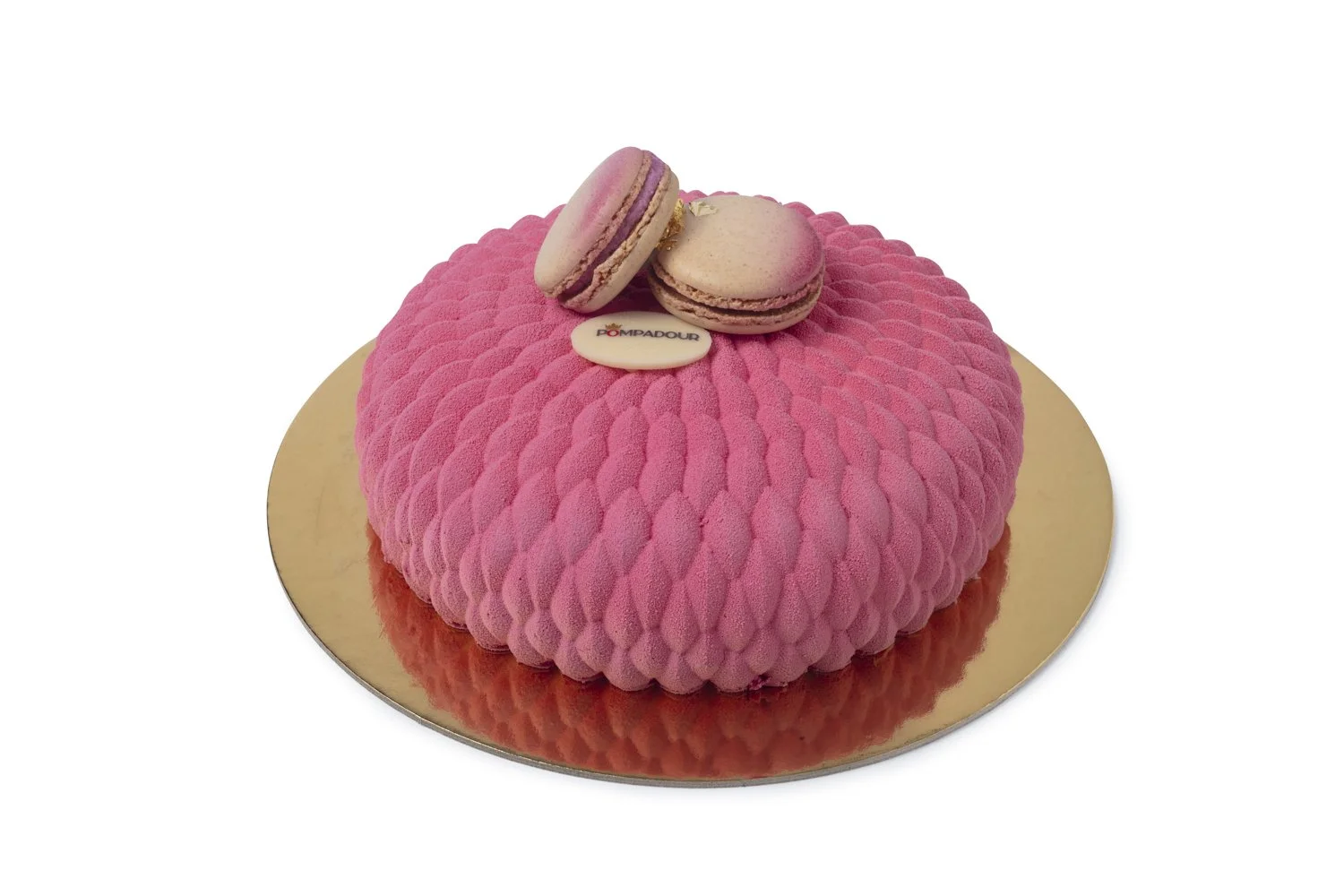Pink textured cake with two macarons and a chocolate disc on top, placed on a gold base. Beverly HIlls food photographer and stylist 
