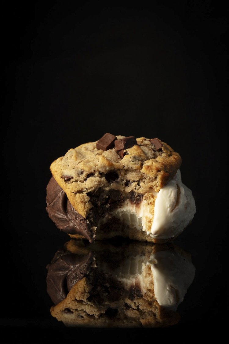 Cookie ice cream sandwich on a black background - moody dessert photography