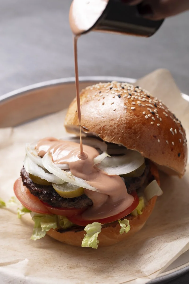 Dripping sauce on a hamburger - Los Angeles food photographer and stylist 